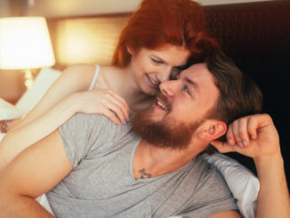 Happy couple in bed showing emotions and love