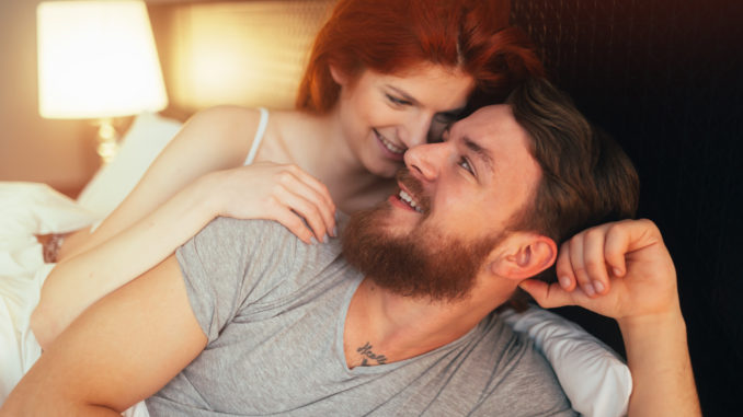 Happy couple in bed showing emotions and love