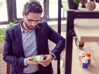 man reading an inscription on the bottle