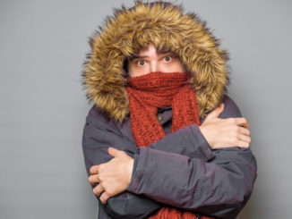 Studio portrait of man feeling cold and wearing warm clothes