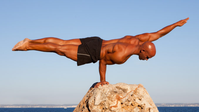 Balance strong man balancing on rock.