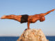 Balance strong man balancing on rock.