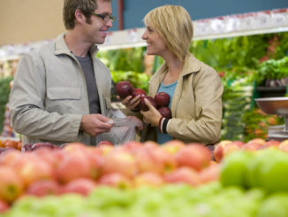 Couple choosing apples in grocery store