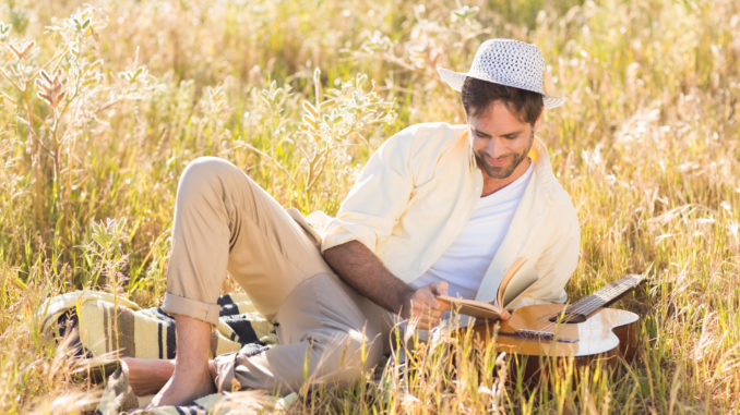 Happy man reading a book on a sunny day