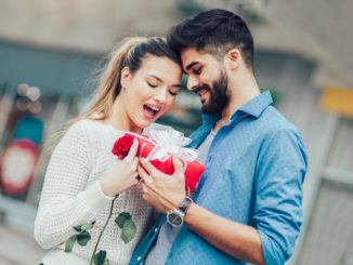 Romantic Man giving flower and gift box to women for Valentines day