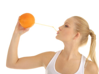 Woman drinking orange juice through a straw isolated on white