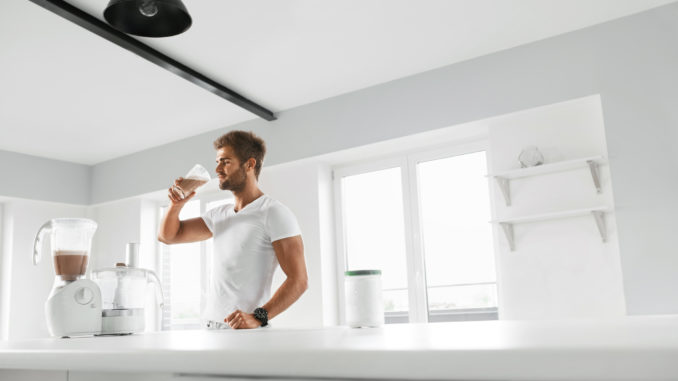 Handsome Happy Smiling Man With Muscular Body Drinking Protein Shake Before Workout.