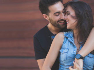 Portrait of happy couple cuddling together touching each other nose