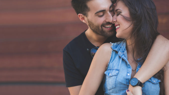 Portrait of happy couple cuddling together touching each other nose