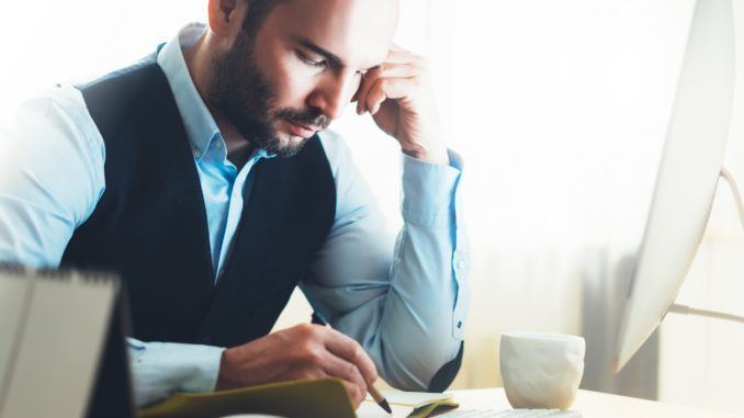 Bearded young businessman working on modern office.