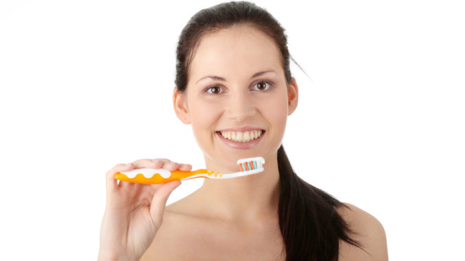 Young beautiful woman washing her teeth,