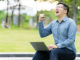 Attractive asian happy man gesture or raise hand excited screaming yes reading online