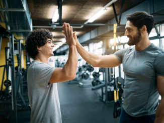 Fit men high fiving at the gym