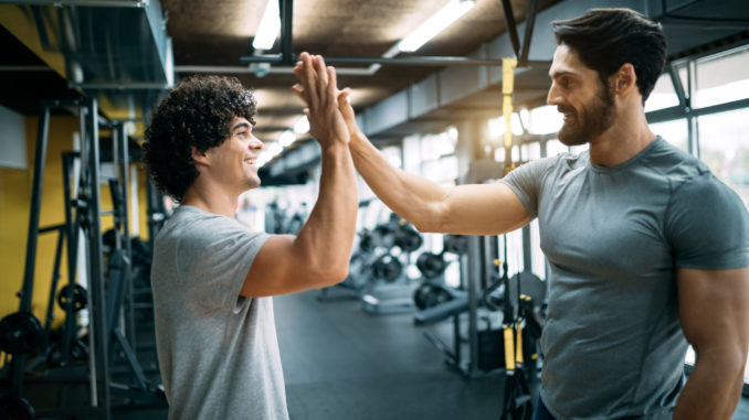 Fit men high fiving at the gym