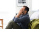 Stressed man sitting on floor at home