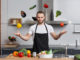 Young man in the kitchen juggling with vegetables