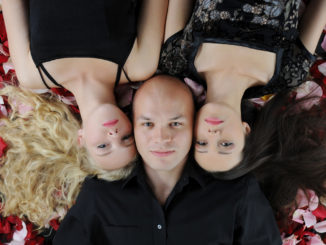 Beautiful women and man lying on the rose petals