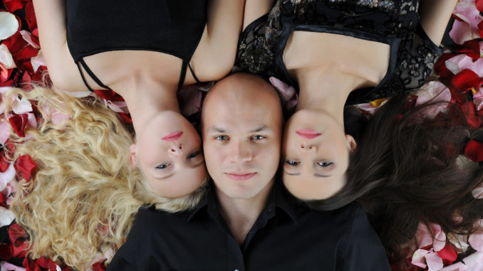 Beautiful women and man lying on the rose petals