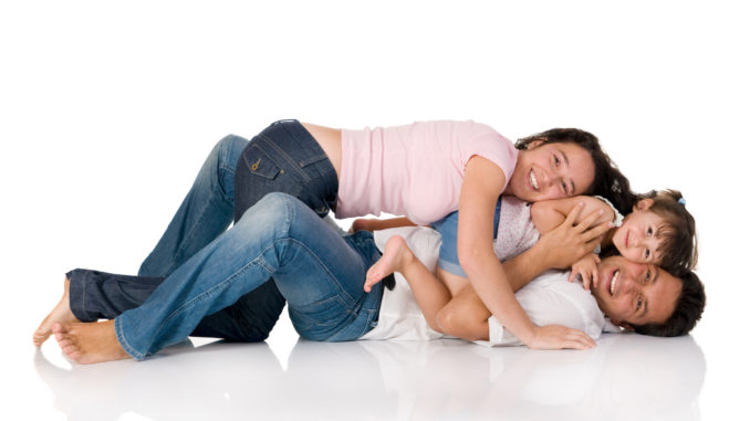 Happy smiling family lying down together isolated on white background