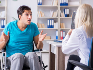 Disabled men in wheel chair visiting women doctor