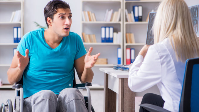 Disabled men in wheel chair visiting women doctor