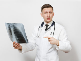 Perplexed focused doctor man with X-ray of lungs