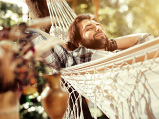 So comfortable. Nice happy man smiling while sleeping in the hammock