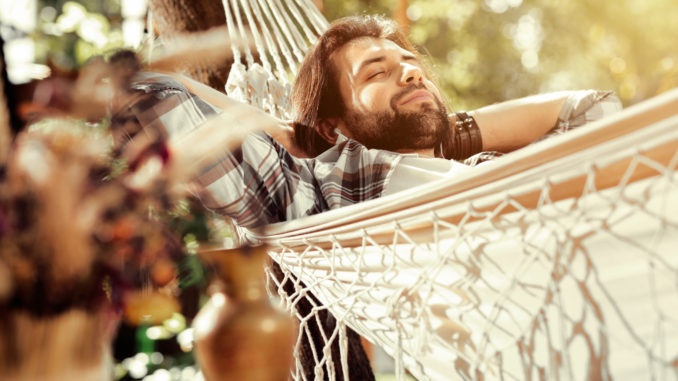So comfortable. Nice happy man smiling while sleeping in the hammock