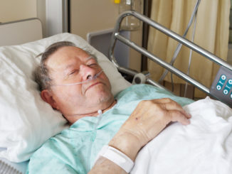 Portrait of sick old man in hospital bed