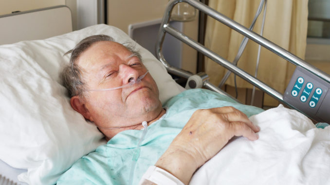 Portrait of sick old man in hospital bed