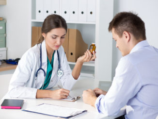 Female medicine doctor prescribing pills to her male patient