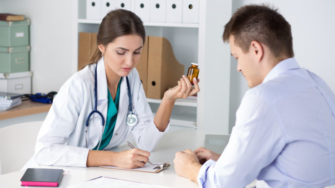 Female medicine doctor prescribing pills to her male patient