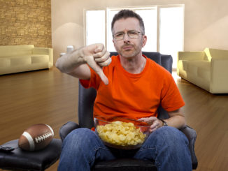 man watching football on TV with potato chip snacks