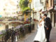 Happy married couple bride and groom kissing & hugging in old french street