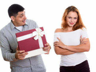 men looking at women while opening gift box looking surprised