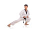 Full length portrait of a male traditional martial art practitioner stretching his right leg