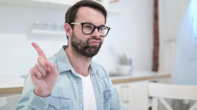 The Serious Beard Young Man saying No with Finger Gesture