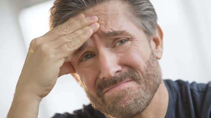 Closeup of mature man with headache rubbing forehead