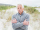 Portrait of a casual senior man feeling cold at the beach