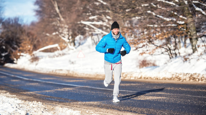 Active man, jogging and running during a sunny winter day. Outdoor working out concept