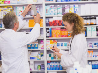 Pharmacists searching medicines with prescription at hospital pharmacy