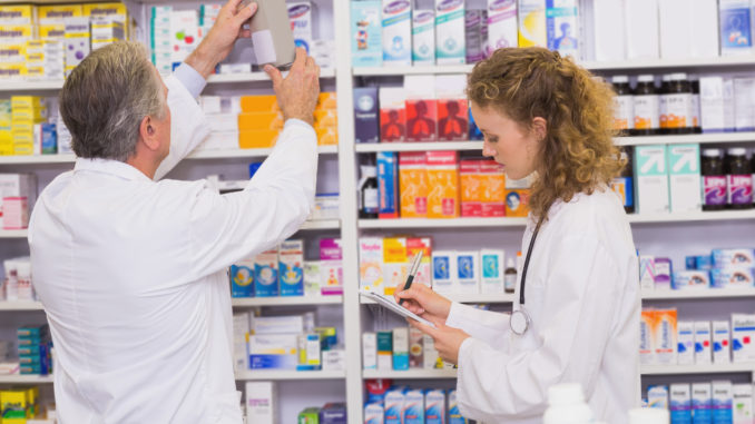 Pharmacists searching medicines with prescription at hospital pharmacy