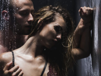 Couple taking a shower during which a men touches a women passionately