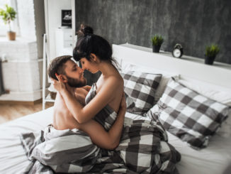 Man and woman making love in bed.