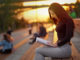 Young Asian woman reading a book in the evening at sunset. outdoor city portrait.