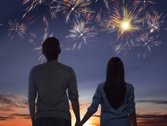 Young asian couple watching spectacular fireworks on the sky