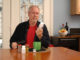 A man of retirement age reading the label of a vitamin bottle