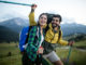 Backpackers happy beautiful couple hiking with sticks