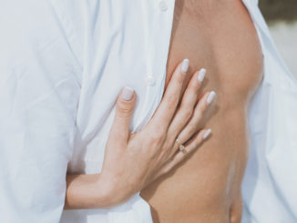 muscular naked man and female hands unbuckle his jeans