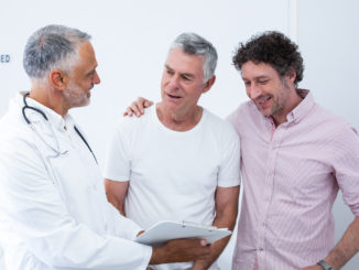 Senior men and his guardian talking to the doctor in hospital